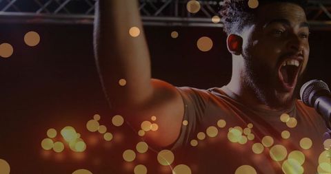 Live Singer Raising Arm with Microphone and Festive Bokeh Lights