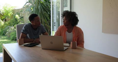Couple Discusses Plans with Laptop and Coffee at Home