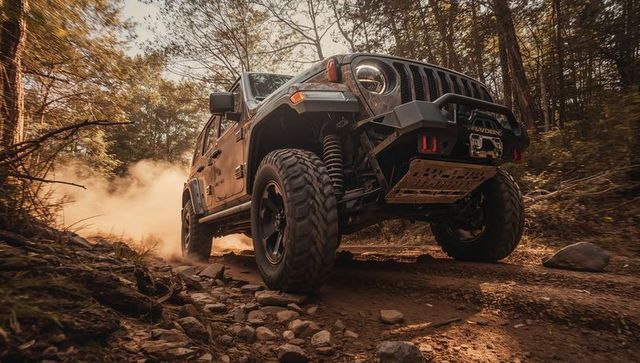 Rugged 4x4 climbing rocky forest trail with winch, skid plate and heavy-duty suspension