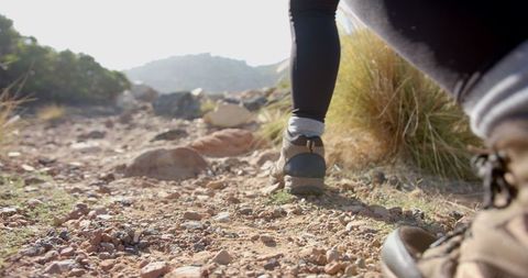 Woman Trekkign Rocky Mountain Trail Under Soft Light Outdoors Adventure
