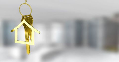 Gold house-shaped keychain with keys in modern interior