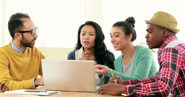 Diverse Group of Young Professionals Collaborating on Laptop in Cozy Office - Download Free Stock Images Pikwizard.com