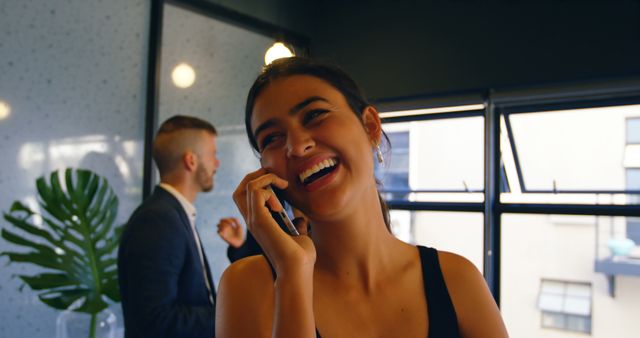 Businesswoman Laughing on Phone Call in Office - Download Free Stock Images Pikwizard.com