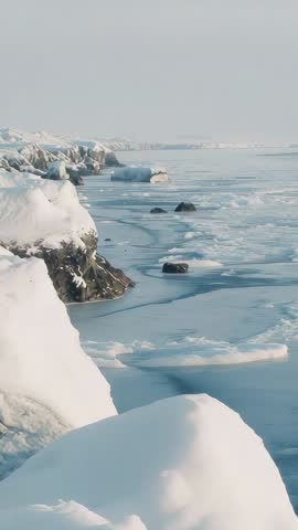 Vertical Arctic Coastline with Drifting Ice Floes and Snow-Covered Rocks, Calm Winter Loop