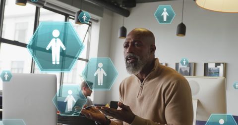 Man in Office Engaging in Video Call with Holographic Icons Overlay