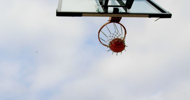 Basketball swishing through hoop against clear sky - Download Free Stock Images Pikwizard.com