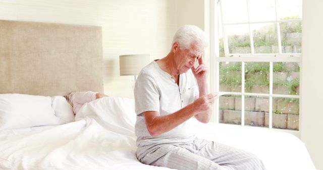 Worried Senior Man Sitting on Bed in Morning - Download Free Stock Images Pikwizard.com