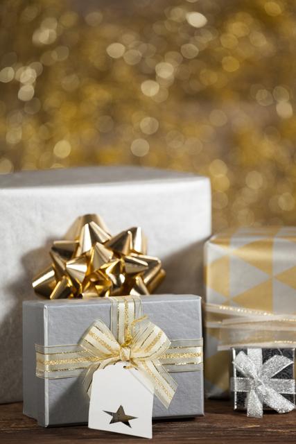 Close-up of beautifully wrapped Christmas gifts with golden decorations on a wooden table. Ideal for holiday-themed promotions, festive greeting cards, seasonal advertisements, and social media posts celebrating Christmas and gift-giving.