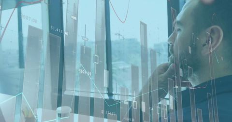 Businessman Analyzing Financial Graphs in Modern Office Environment