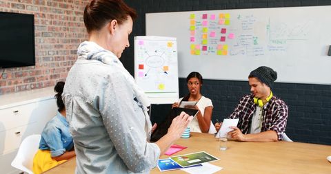 Businesswoman Utilizing Tablet During Collaborative Meeting