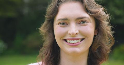 Smiling woman in garden with soft natural light