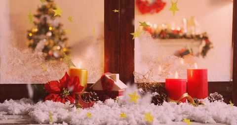 Cozy christmas windowsill display glowing candles, poinsettia, miniature house