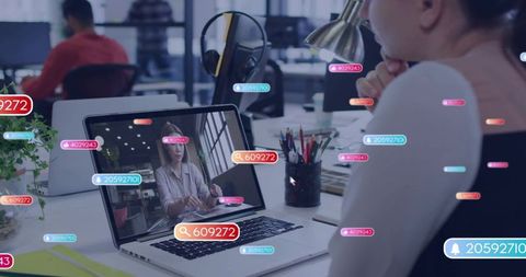 Asian woman engaging in virtual collaboration on laptop surrounded by floating social tags