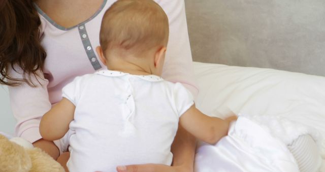 Mother Holding Baby on Bed in Soft Light - Download Free Stock Images Pikwizard.com