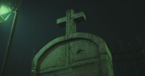 Eerie tombstone at night in foggy cemetery
