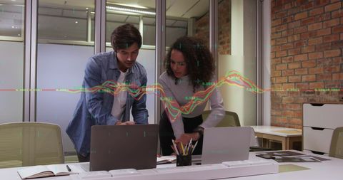 Multiracial Coworkers Collaborating on Data Analysis in Office