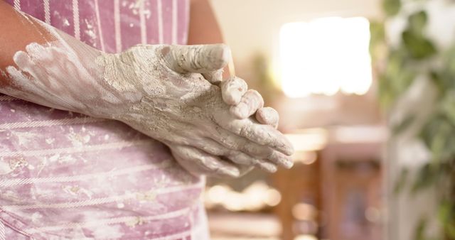 Hands covered in flour preparing dough in kitchen, showcasing the preparation process. Ideal for content on baking, food blogs, cooking tutorials, culinary arts, and homemade recipes.