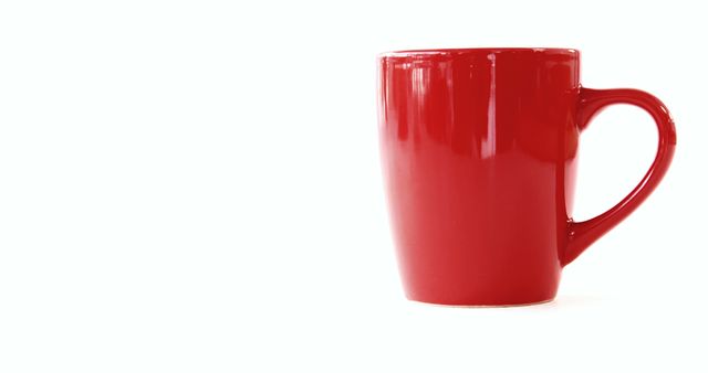 A vibrant red mug stands out against a clean white background, with copy space. Its bold color makes it a striking subject for a minimalist design or a backdrop for text in advertising.