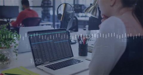 Female professional analyzing laptop data in open office with digital waveform overlay