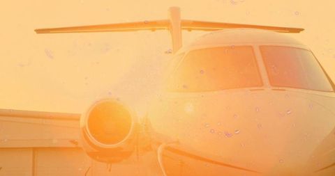 Luxury private jet glowing in sunset on airport tarmac