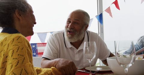 Biracial family dining with american flags decorating table
