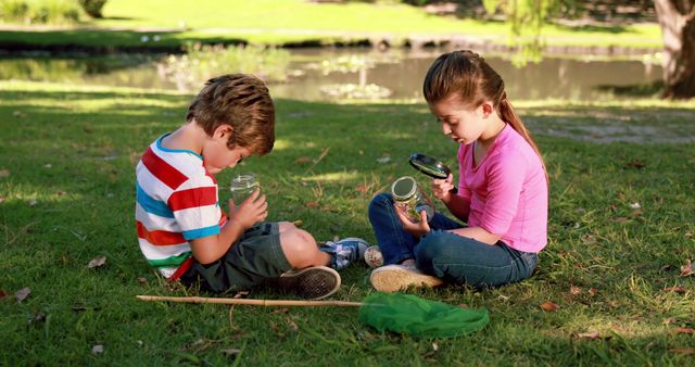 A young Caucasian boy and girl are engaged in an outdoor activity, examining contents of glass jars in a park, with copy space. Their curiosity suggests a learning experience, related to a school science project or a nature exploration hobby.