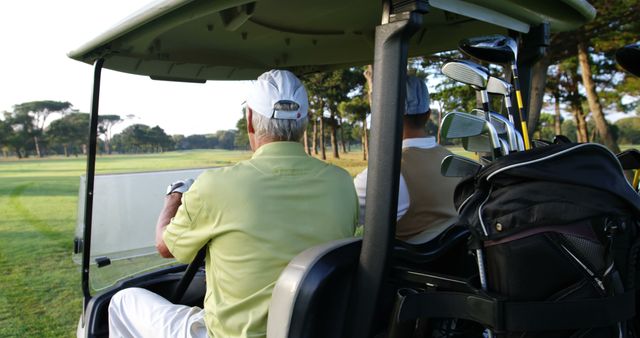 Senior golfers driving a golf cart on a scenic course; ideal for promoting retirement lifestyle, golfing holidays, and leisure activities aimed at seniors. This image is perfect for use on websites, brochures, and advertisements related to outdoor recreation, golfing events, and senior living communities.