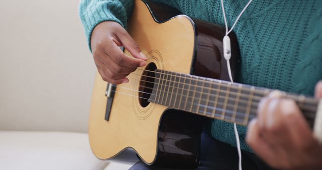 Person Playing Acoustic Guitar and Listening to Music with Earphones - Download Free Stock Images Pikwizard.com