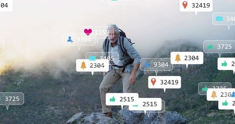 Senior hiker climbing misty mountain ridge with social media notifications and icons