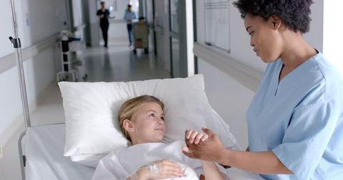 Nurse Providing Tender Care to Young Patient in Hospital Ward