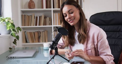 Woman in Home Office Adjusting Microphone for Podcast Recording