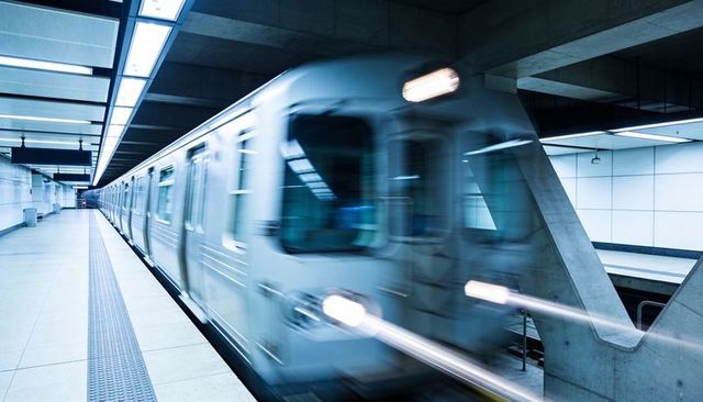 Rushing Silver Subway Train Blurring Through Modern Underground Metro Platform at Speed