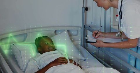 Pediatric nurse leaning over hospital bed taking notes on clipboard while comforting child with ecg