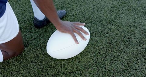 Athlete Positioning Rugby Ball on Field for Precision Kick