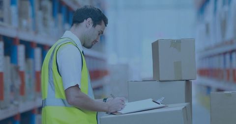 Warehouse clerk checking inventory on clipboard wearing high-visibility vest in aisle