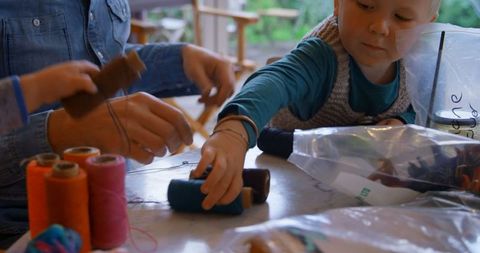Father and children exploring creativity with yarn at home