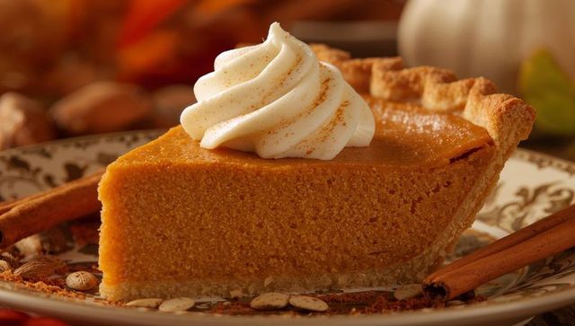 Cream-Topped Pumpkin Pie Slice on Ornate Plate with Cinnamon Sticks, Autumn Dessert