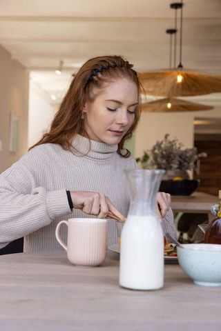 Cozy Morning Meal: Woman Enjoying Breakfast at Home