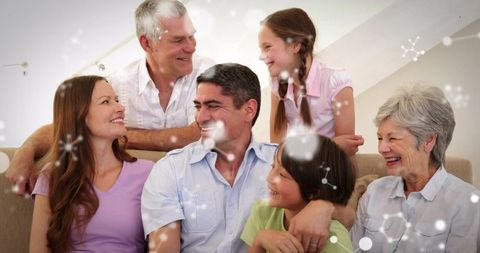 Multigenerational family sharing laughter and affection on couch, smiling and connecting
