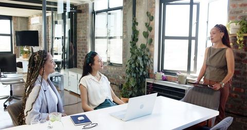 Collaborative Meeting in Urban Office Space with Diverse Coworkers