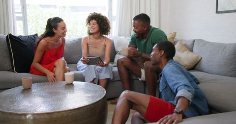 Diverse Friends Relaxing with Tablet in Cozy Modern Living Room