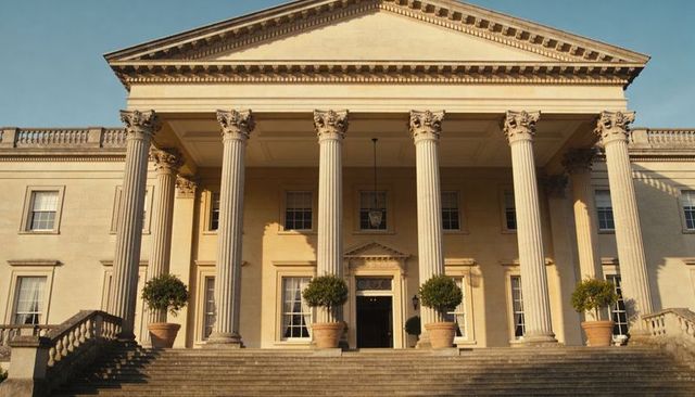 Neoclassical mansion entrance with six corinthian columns at golden hour