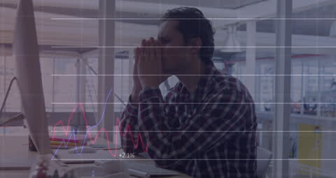 Tired Businessman Analyzing Data with Overlaid Graphs