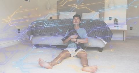 Asian Man Cradling Small Dog on Bedroom Floor with Futuristic Circuit Overlay