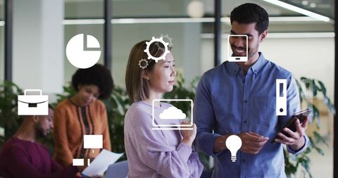 Business team collaborating and discussing strategy with digital icons overlaid on tablet