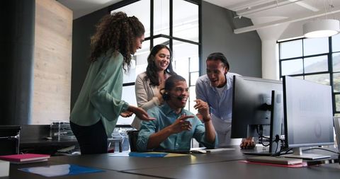 Diverse Colleagues Celebrating Success with Computer in Modern Office