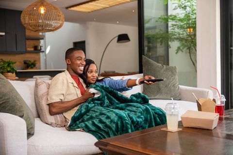 Happy Couple Enjoying Movie Time on Cozy Living Room Sofa