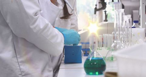 Scientists in Laboratory Analyzing Experiments with Blue Gloves