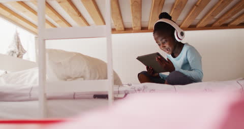 African American Girl Enjoying Tablet on Bunk Bed