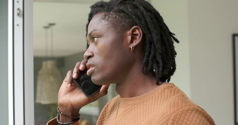 Pensive African American Man Talking on Phone by Window in Modern Home Interior in Quilted Top